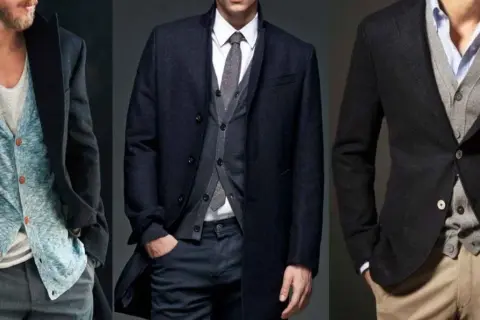 Drei Männer tragen stilvolle Outfits. Links ein blauer Cardigan unter einem dunklen Mantel. Mitte ein grauer Cardigan unter einem dunklen Mantel. Rechts ein grauer Cardigan unter einem dunklen Sakko.