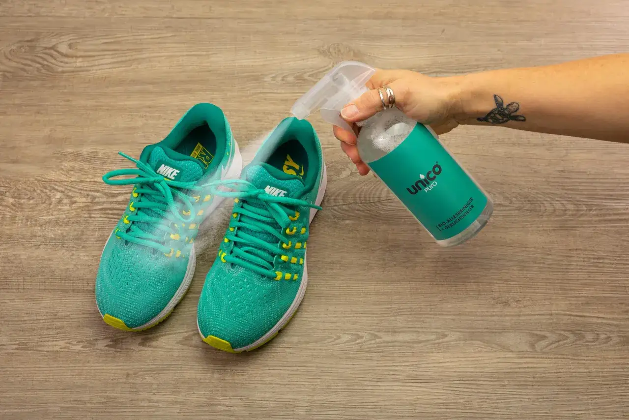 Grüne Nike-Sneaker werden mit einem Spray besprüht, um zu verhindern, dass die schuhe stinken. Was tun?